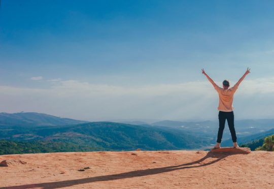 imagen de persona en lo alto de una montaña. superando momentos de fristeza