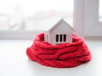 imagen de portada del artículo sobre calderas y calentedores de gas en la que aparece un casa rodeada de una bufanda roja