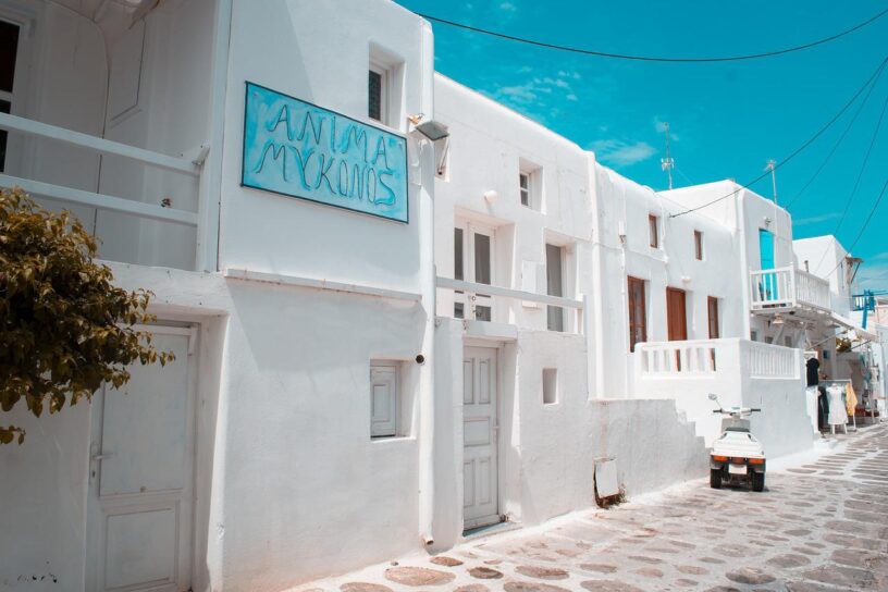 Imagen de portada del artículo sobre lo imperdible en un viaje a Grecia. Aparece la imagen de una calle típica de Mykonos