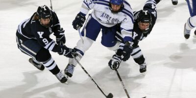 imagen en la que aparecen tres jugadores de hockey sobre hielo disputando por el disco